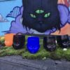 Set of Baby Head Cups in fron of a cat mural