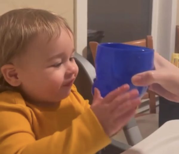 Child kissing a Blue Baby Head Cup