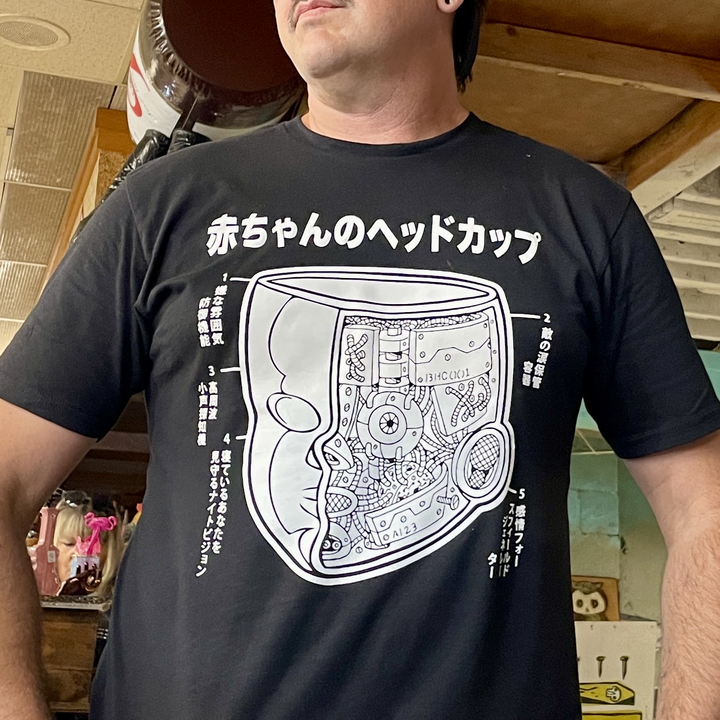 Baby Head Cup Mechanism T-Shirt worn by a man.