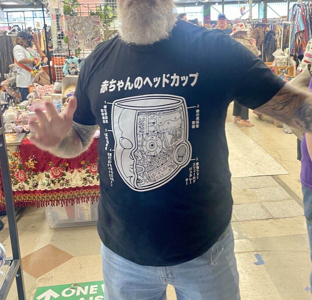 Man wearing a black t-shirt with a white Baby Head Cup Image